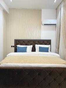 a bedroom with a large bed with blue pillows at 6a Thompson Avenue in Lagos