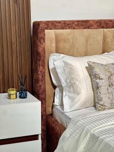 a bed with a night stand next to a white bed at 6a Thompson Avenue in Lagos