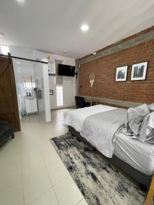 a bedroom with a brick wall and a bed with a rug at Loft cerca de todo con cochera in León