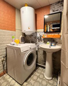 a bathroom with a washing machine and a sink at Ela in Ushguli