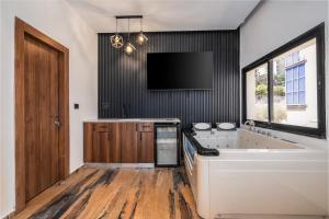 a large bathroom with a tub and a tv on the wall at Hotel 46 in Haifa +60 photos