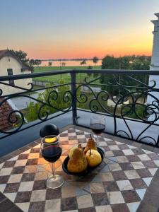ein Tisch mit zwei Gläsern Wein auf einem Schachbrett in der Unterkunft White Palace in Palić