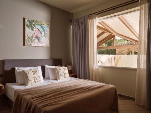 a bedroom with a bed and a large window at Ilision - Contemporary Living Residences in Argassi