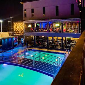 a swimming pool in front of a building at night at Perly Gate Residence Uyo in Uyo +9 photos