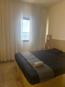 a bedroom with a bed and a window at Flat frente à praia !! Boqueirão Santos! in Santos +20 photos