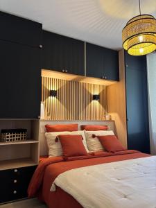 a bedroom with a large bed with red and white pillows at Le Ruby in Amboise