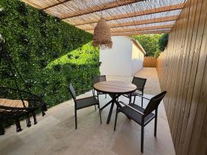 a table and chairs on a patio with a fence at Le Ruby in Amboise