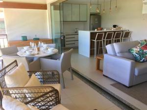a kitchen and a living room with a table and chairs at Ykutiba Imbassaí - Apartamento 2 Quartos - H104 in Imbassai