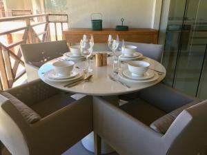 a white table with plates and glasses on it at Ykutiba Imbassaí - Apartamento 2 Quartos - H104 in Imbassai