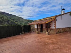 a white house with a roof with a dirt driveway at Casa Béjar in Quesada