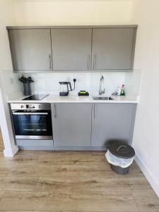 GlantonにあるTurnpike Houseの白いキャビネットとシンクのあるキッチン