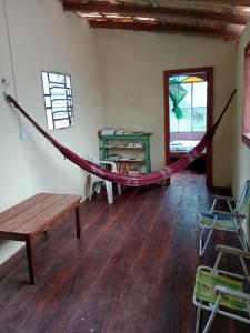 a hammock in a room with a table and chairs at Pousada Sol e praia in Manaus