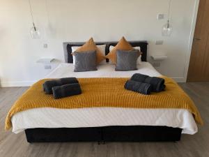 a large bed with black pillows on top of it at Turnpike House in Glanton