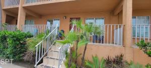 a building with stairs and palm trees in front of it at Fiesta Sol #110 home in South Padre Island +68 photos