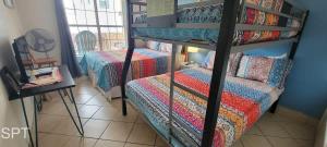 a bedroom with two bunk beds with a couch at Fiesta Sol #110 home in South Padre Island