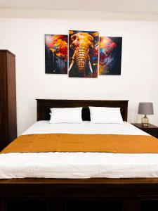 a bedroom with three paintings of an elephant on the wall at Happy Haven Homestay in Anuradhapura