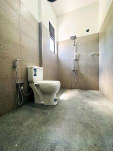 a bathroom with a toilet and a shower at Happy Haven Homestay in Anuradhapura