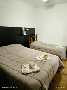 two beds in a room with towels on them at Hotel LE MIRAGE in Mar del Plata