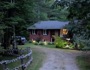 a house with christmas lights in front of a driveway at Suite in the Bush-Private Apartment in Bancroft