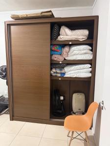a closet with a wooden door and a chair at Oceanfront apartment with beautiful view in Palhoça