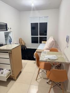 a small room with a bed and a table and chairs at Oceanfront apartment with beautiful view in Palhoça