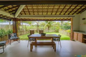 a patio with a table and chairs and a view of a yard at Ykutiba Imbassaí - Bangalô - J01 in Imbassai