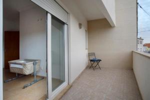 a balcony with a glass door and a chair at AO - Tina House Ferrel in Ferrel