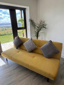 a yellow couch in a living room with a window at Turnpike House in Glanton +89 photos