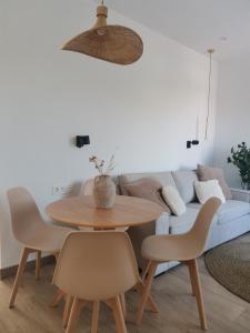 una mesa y sillas en una sala de estar con sofá en Ático El Limón, en Alhaurín de la Torre