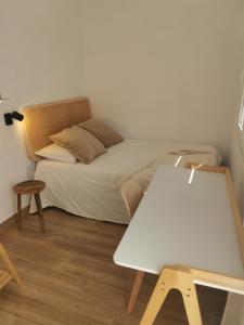 Un pequeño dormitorio con una cama y una mesa. en Ático El Limón, en Alhaurín de la Torre 1 foto más