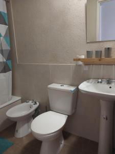 a bathroom with a toilet and a sink at Pichincha departamento in Rosario