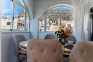 una sala da pranzo con tavolo, sedie e finestre di Villa para 12 personas en Santa Pola, frente a isla Tabarca a Gran Alacant Altre 144 foto