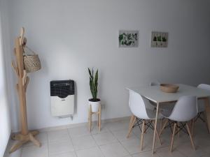 a white dining room with a table and chairs at Pichincha departamento in Rosario +9 photos