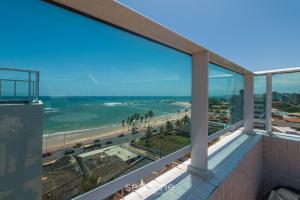 una vista de la playa desde el balcón de un edificio en SIP - Belos Estúdios em Salvador, en Salvador