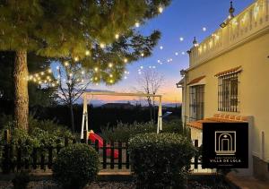 einen Zaun vor einem Haus mit Lichtern in der Unterkunft Villa de L o L a, Pura Calma & Jakuzzi, a 50 minutos de Málaga y 45 de Córdoba in Lucena