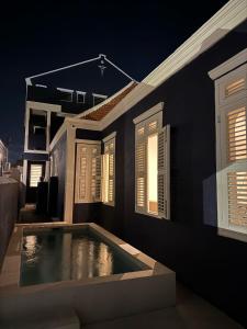 威廉斯塔德Kas Leon - Villa Heritage Retreat的一栋窗户前有游泳池的房子