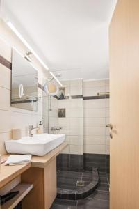 a bathroom with a sink and a shower at Luxury 2BR Penthouse Marina & Sea Views in Piraeus +28 photos