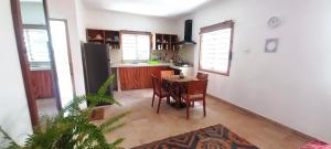 a kitchen and dining room with a table and chairs at Busy Bee Nature Residence in Mariama Kunda