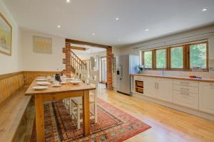 a large kitchen with a wooden table and a dining room at Ruston Lodge in Thursford