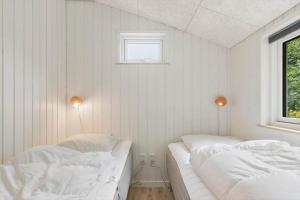 2 Betten in einem Zimmer mit weißen Wänden und einem Fenster in der Unterkunft SJ203 Børkop - Bjørnsvej 16 in Børkop