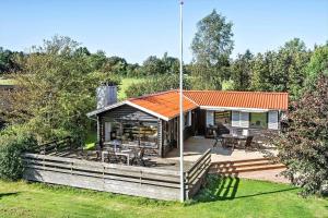ein Haus mit einem orangefarbenen Dach und einer Terrasse in der Unterkunft SJ203 Børkop - Bjørnsvej 16 in Børkop