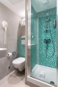 uma casa de banho com um WC e uma cabina de duche em vidro. em Hotel OHM by Happyculture em Paris