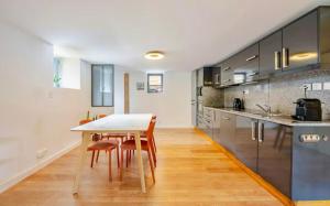 a kitchen with a table and chairs in a room at Côté Jardin, Entre lac et montagne in Publier