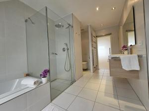 un baño con ducha y bañera en Luxurious 3BR Penthouse w terrace&parking, en Luxemburgo 24 fotos más