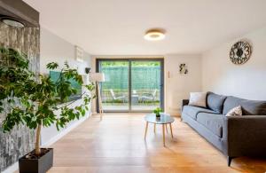 a living room with a couch and a table at Côté Jardin, Entre lac et montagne in Publier