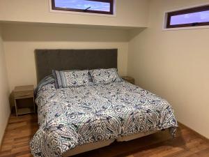 a bedroom with a bed with a comforter and two windows at Contacto con la naturaleza y cerca de Santiago in María Pinto +47 photos