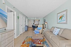 a living room with a couch and a table at Oceanfront Condo at Oceania Beach Club - Pool, Balcony, Sleeps 6, Walk to Flagler Ave! in Chicken Island