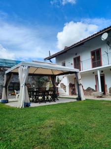 a picnic table under a tent in front of a house at L'Oasi di Mario in Pinerolo