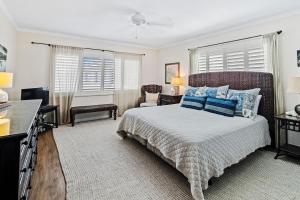 une chambre avec un grand lit avec des oreillers bleus dans l'établissement Walk to Beach, Pool & Flagler! Relaxed Condo with Balcony & Full Kitchen, à Chicken Island