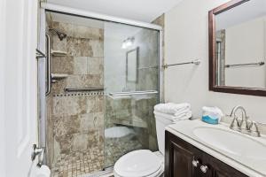 une salle de bain avec une douche, des toilettes et un lavabo dans l'établissement Walk to Beach, Pool & Flagler! Relaxed Condo with Balcony & Full Kitchen, à Chicken Island 8 autres photos